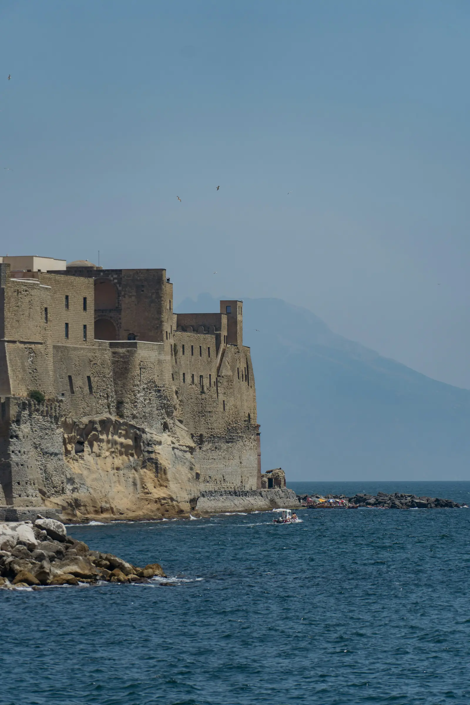 Castel dell'Ovo beside the Bay of Naples with Mount Vesuvius in the distance